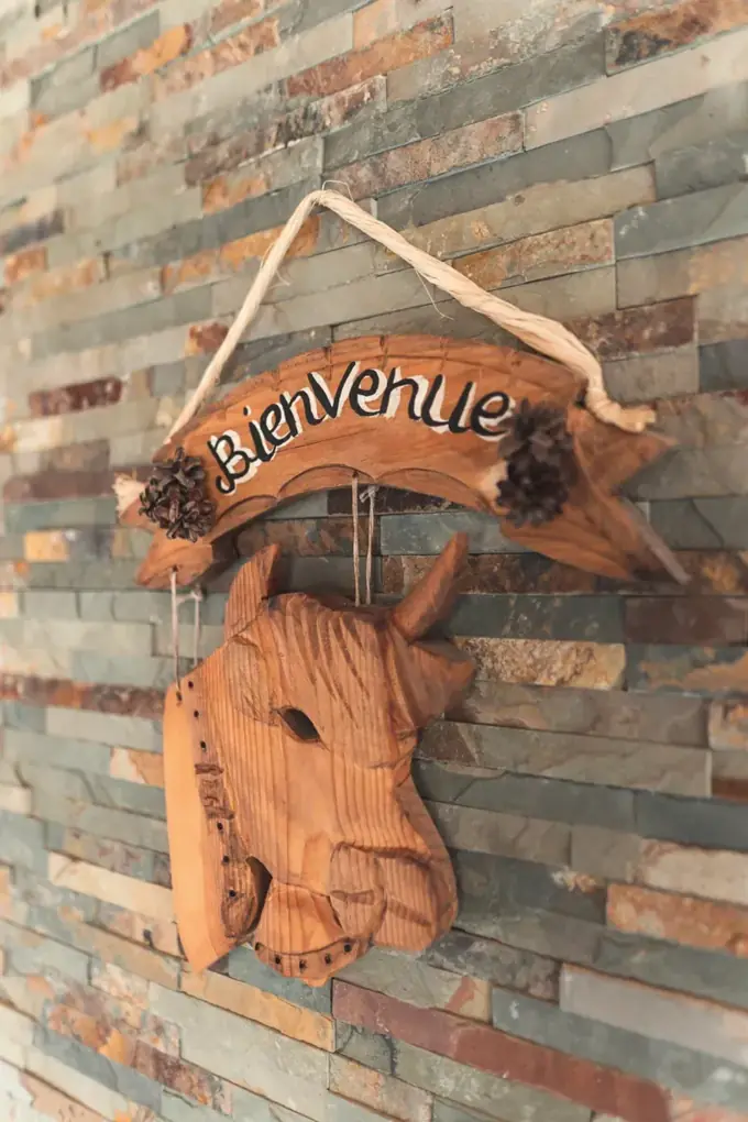 The Bienvenue (Welcome) sign and the carved cow's head on the stone wall